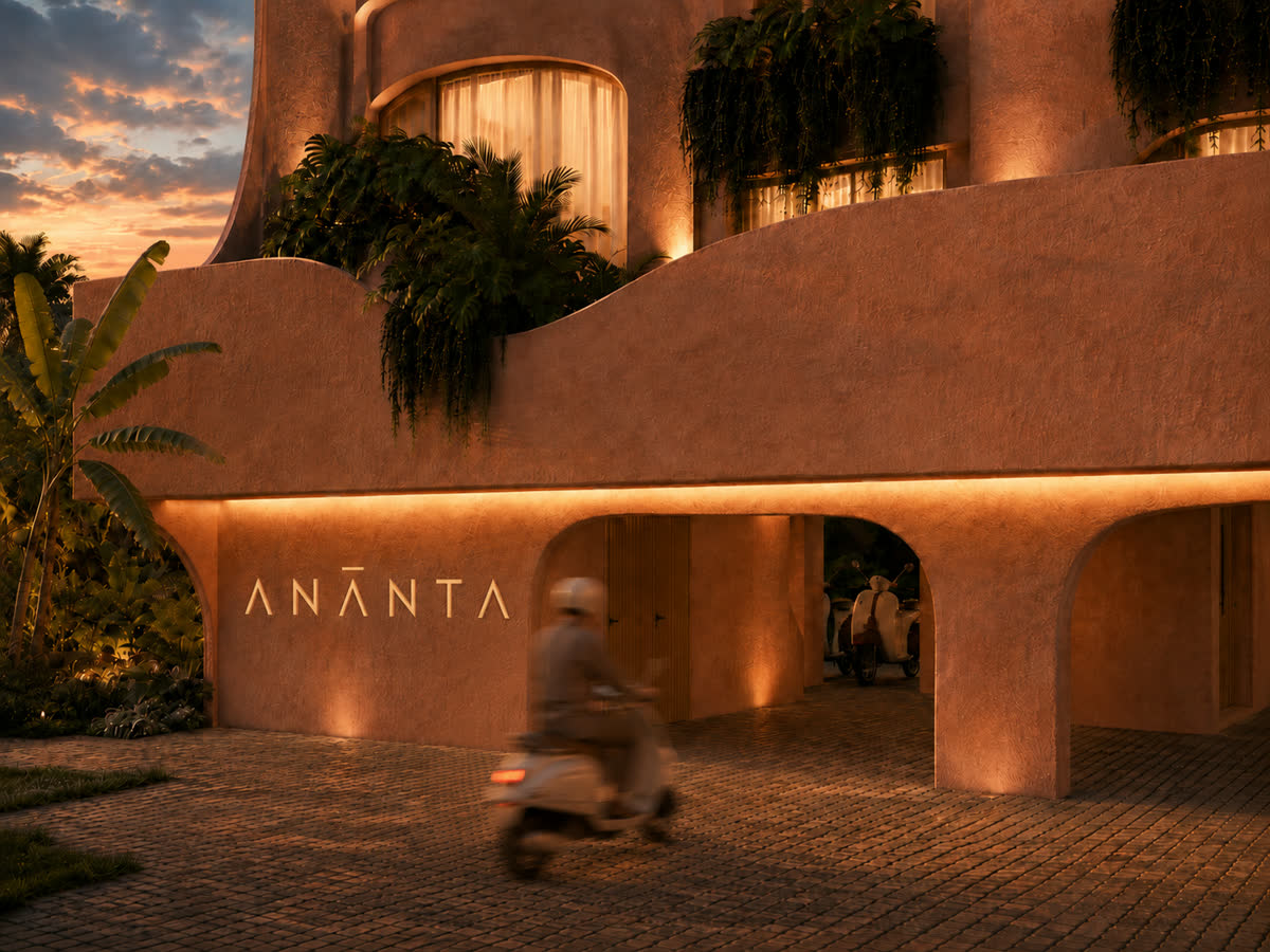 Covered ground-floor parking beneath the building, entrance signage lit at dusk